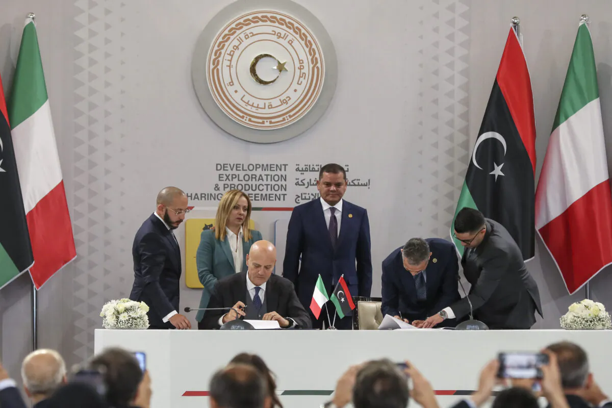 Italian multinational oil and gas company ENI's CEO Claudio Descalzi (front L) and Libyan National Oil Corporation chief Farhat Bengdara (2nd R) sign a bilateral agreement during a ceremony attended by Italy's Prime Minister Giorgia Meloni (back 2nd L) and Libya's Tripoli-based Prime Minister Abdulhamid Dbeibah (C) in the Libyan capital on Jan. 28, 2023. (Mahmud Turkia/AFP via Getty Images)