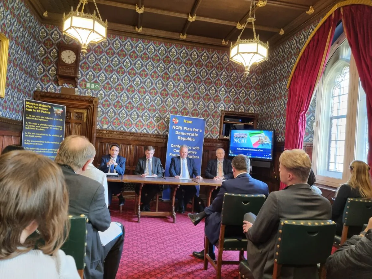 Conservative MPs David Jones (on table, second from left) and Bob Blackman (third from left) address a meeting on Iran at the Jubilee Room in Westminster Hall, London, on Jan. 30, 2023. (Chris Summers/The Epoch Times)