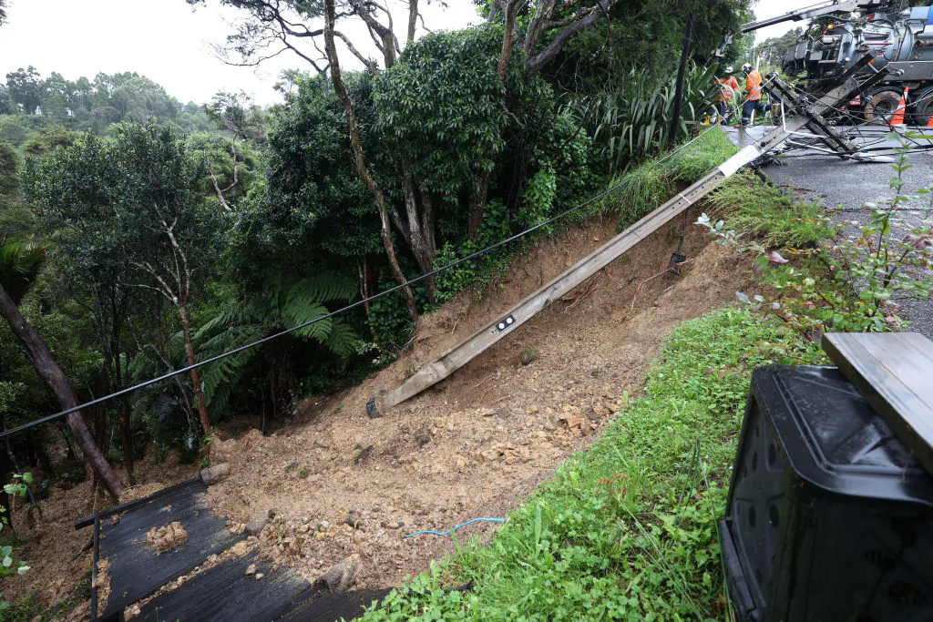 Vector staff work to repair damage after a slip claimed a power pole on Tinopai Rd in Titirangi in Auckland, New Zealand, on Jan. 30, 2023. (Fiona Goodall/Getty Images)