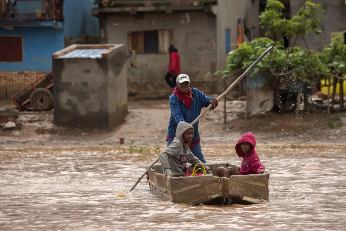 A man steers his boat that is used by residents to move around the street flooded with rain water in Antananarivo, Madagascar, on Jan. 28, 2023. (Alexander Joe/AP Photo)