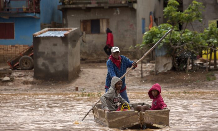 A man steers his boat that is used by residents to move around the street flooded with rain water in Antananarivo, Madagascar, on Jan. 28, 2023. (Alexander Joe/AP Photo)