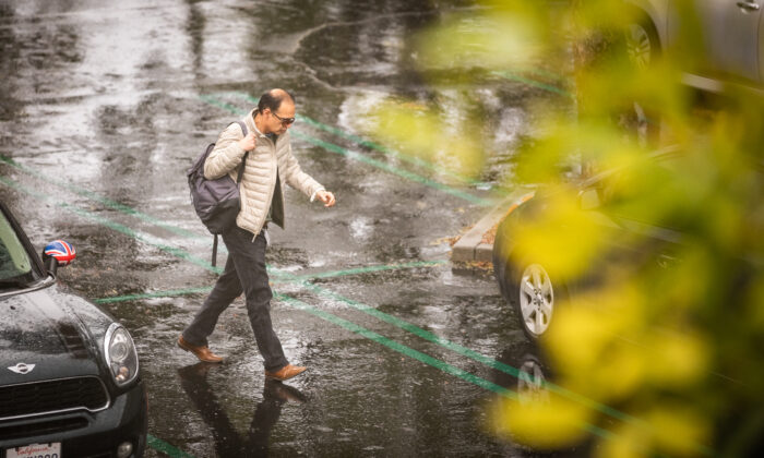 A man runs to his car during rainfall in Irvine, Calif., on Jan. 30, 2023. (John Fredricks/The Epoch Times)