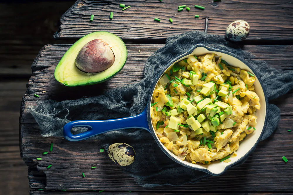 Adding avocado to scrambled eggs is a dish that anyone can make, and can be easily spruced up with corn chips and salsa for a Super Bowl celebration. (Shaiith/Shutterstock)

