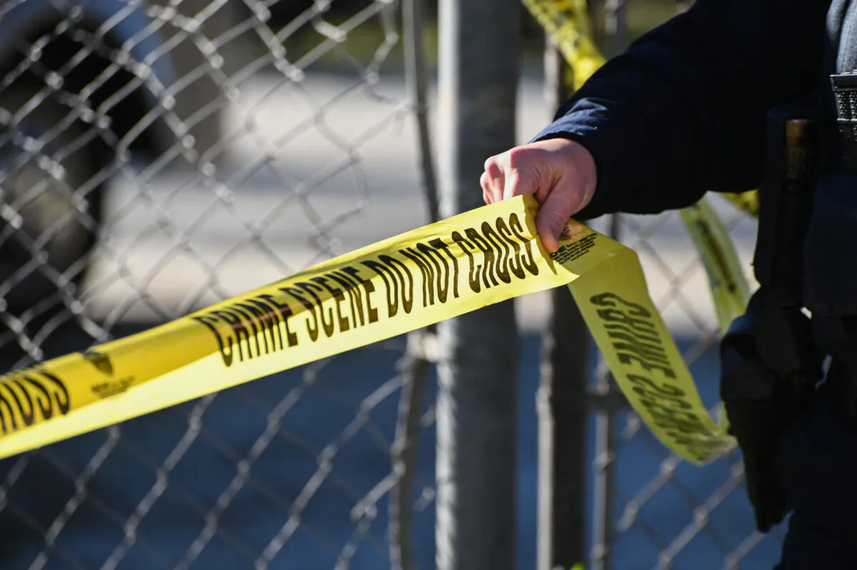 A sheriff officer puts up police tape at a crime scene in a file photo. (Samantha Laurey/AFP via Getty Images)