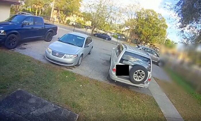 A tinted four-door sedan pulls up near an intersection in Lakeland where people were milling about, and people from inside the vehicle started shooting in all directions, in Lakeland, Fla., on Jan. 30, 2023, in a still from video. (Lakeland Police Department via AP/Screenshot via The Epoch Times)