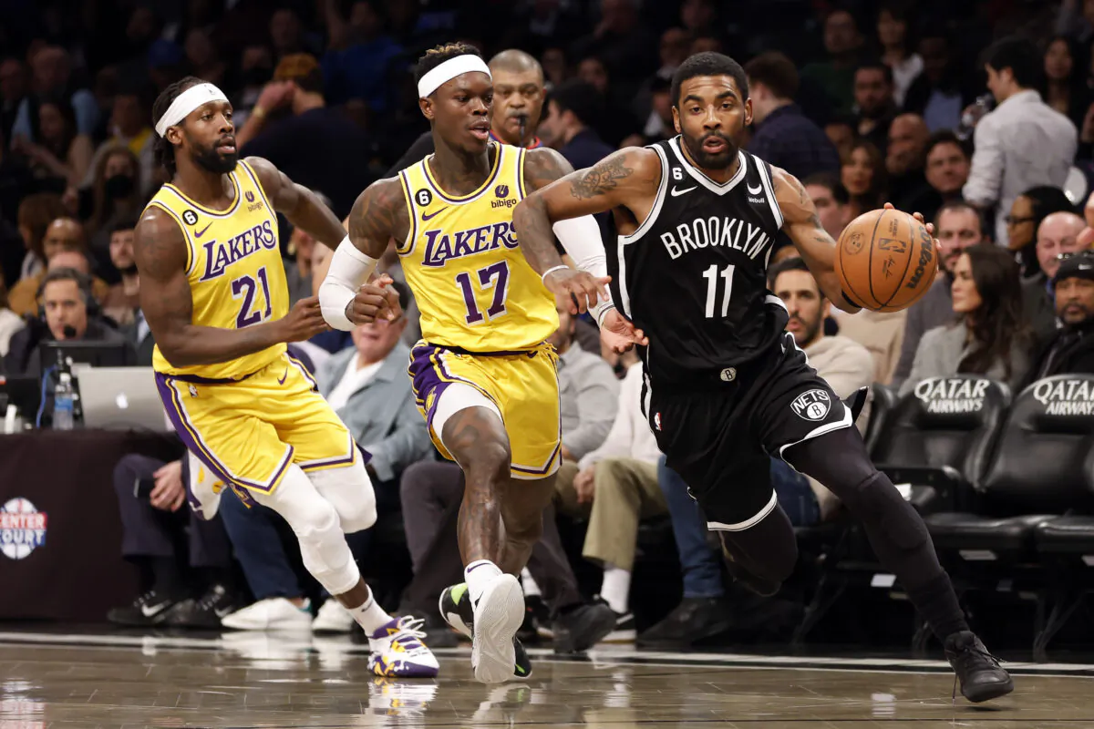 Kyrie Irving (11) of the Brooklyn Nets dribbles as Patrick Beverley (21) and Dennis Schroder (17) of the Los Angeles Lakers defend during the second half  at Barclays Center  in New York on Jan. 30, 2023. (Sarah Stier/Getty Images)