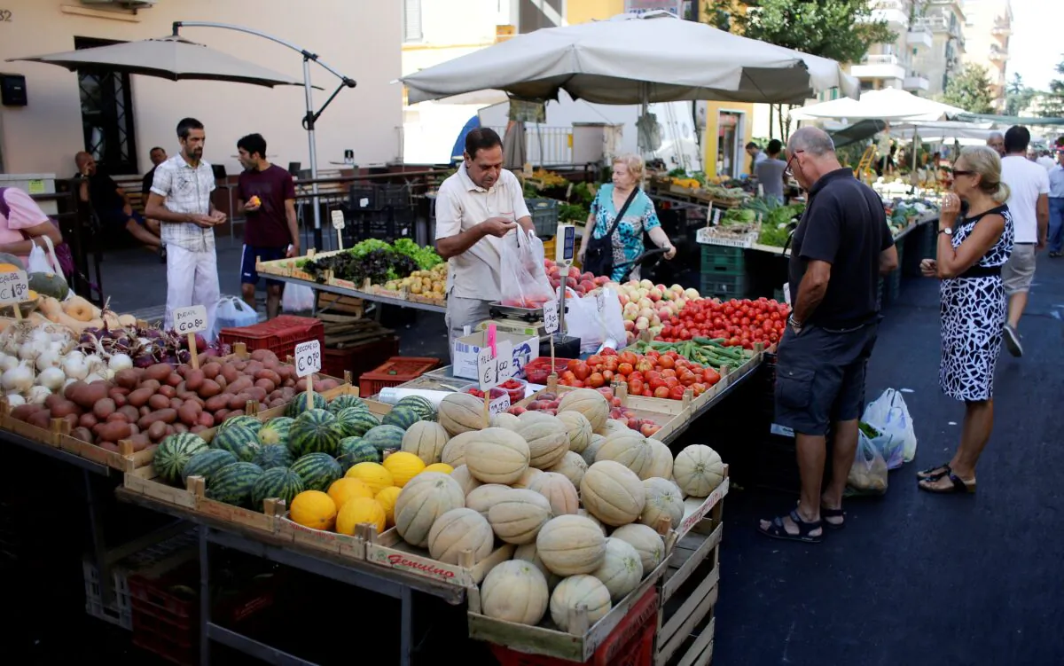 People buy fruit and vegetables in a street market in Rome on Aug. 11, 2016. (Max Rossi/Reuters)