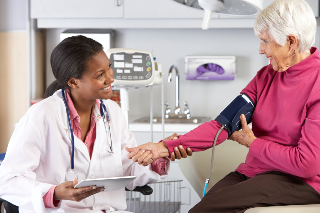 Doctor taking patient's blood pressure. (Shutterstock)