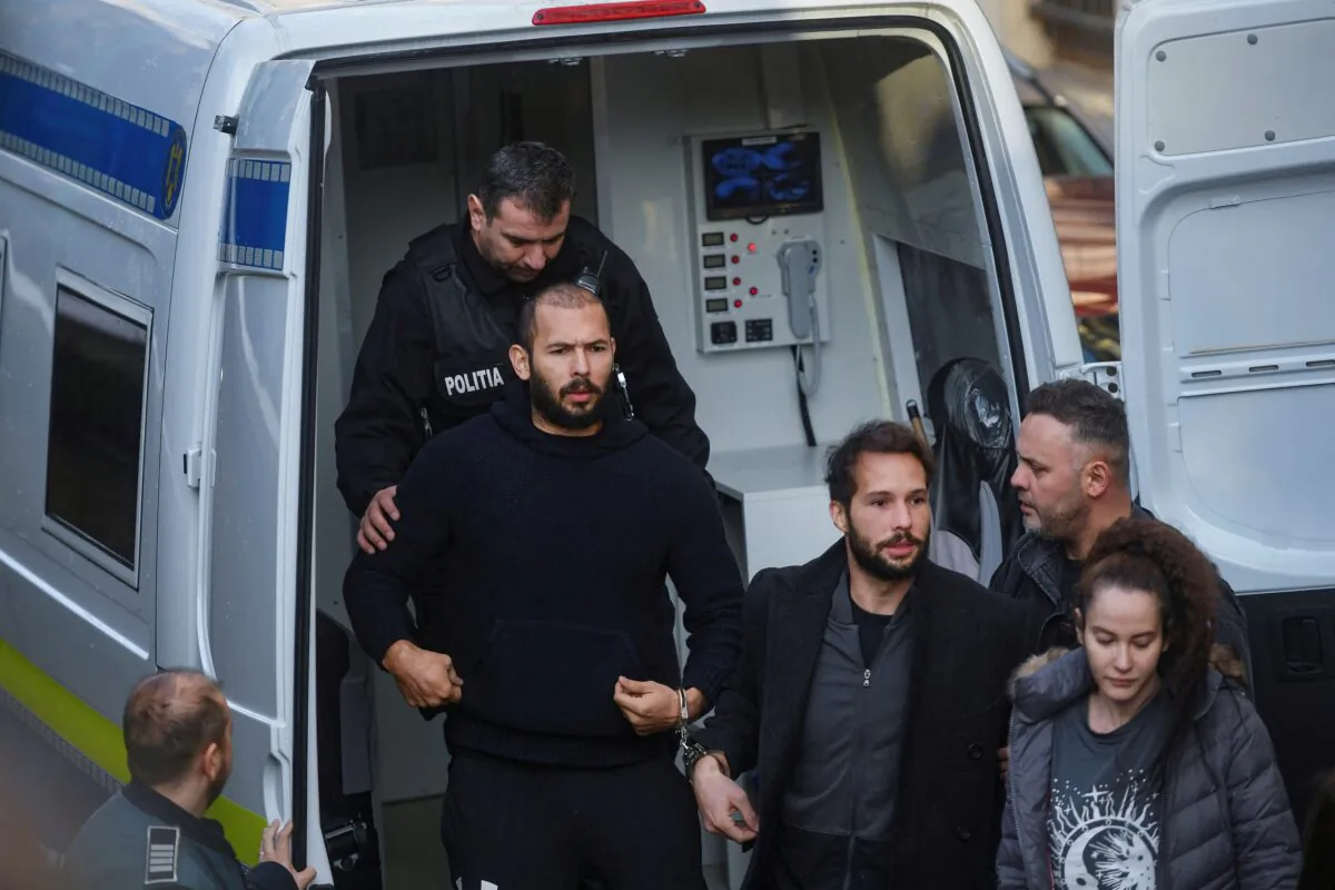 Andrew Tate and Tristan Tate are escorted by police officers outside the headquarters of the Bucharest Court of Appeal, in Bucharest, Romania, on Feb. 1, 2023. (Inquam Photos/Eduard Vinatoru via Reuters)