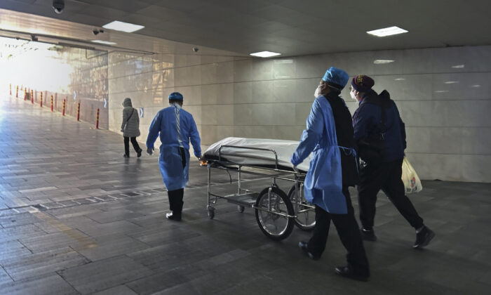 Hospital workers and a relative wheel a body on a gurney out of the busy emergency room at a hospital in Beijing, China, on Jan. 2, 2023. (Getty Images)