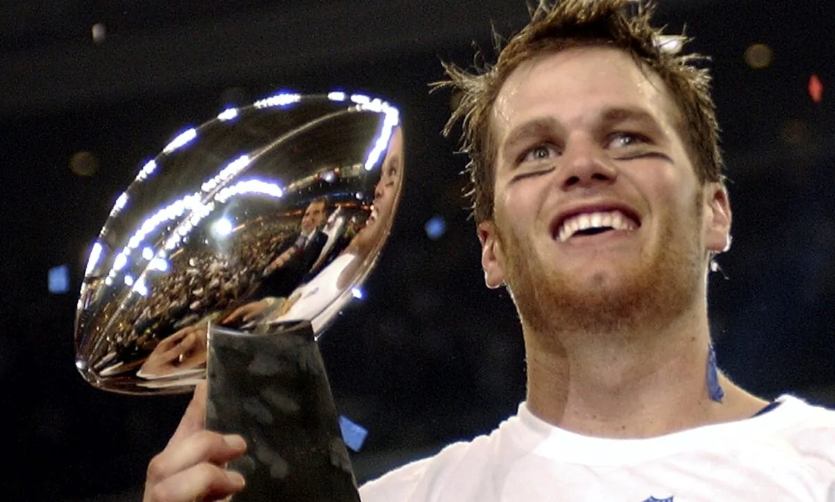 New England Patriots quarterback Tom Brady holds the Vince Lombardi Trophy after the Patriots beat the Carolina Panthers 32–29 in Super Bowl 38 in Houston on Feb. 1, 2004. (Dave Martin/AP Photo)