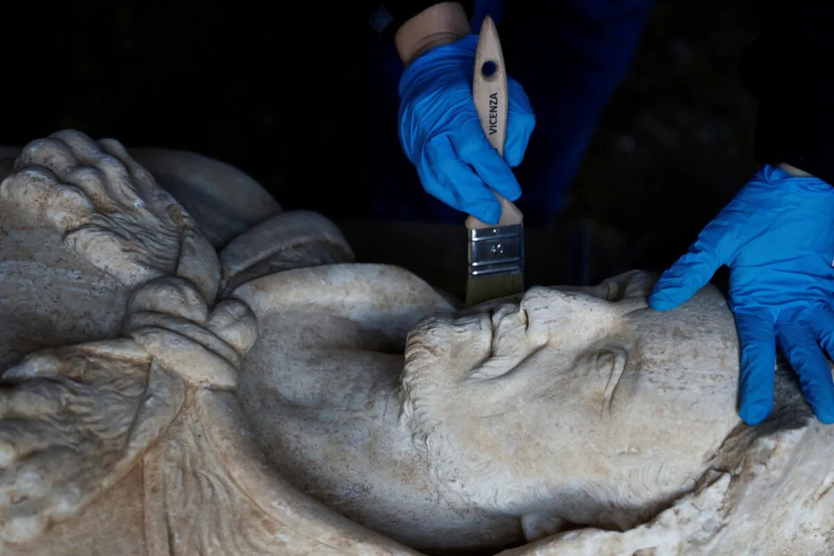 Restorer from Appia Antica archaeological park Sara Iovine cleans a life-sized statue of a Roman emperor posing as the classical hero Hercules after it was discovered during sewer repair works near the old Appian Way, ancient Rome's first highway in Rome on Feb. 1, 2023. (Guglielmo Mangiapane/Reuters)