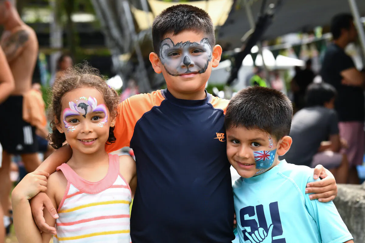 Three children pose for a photo at Southbank during Australia Day 2023 celebrations in Brisbane, Australia, on Jan. 26, 2023. (AAP Image/Jono Searle)