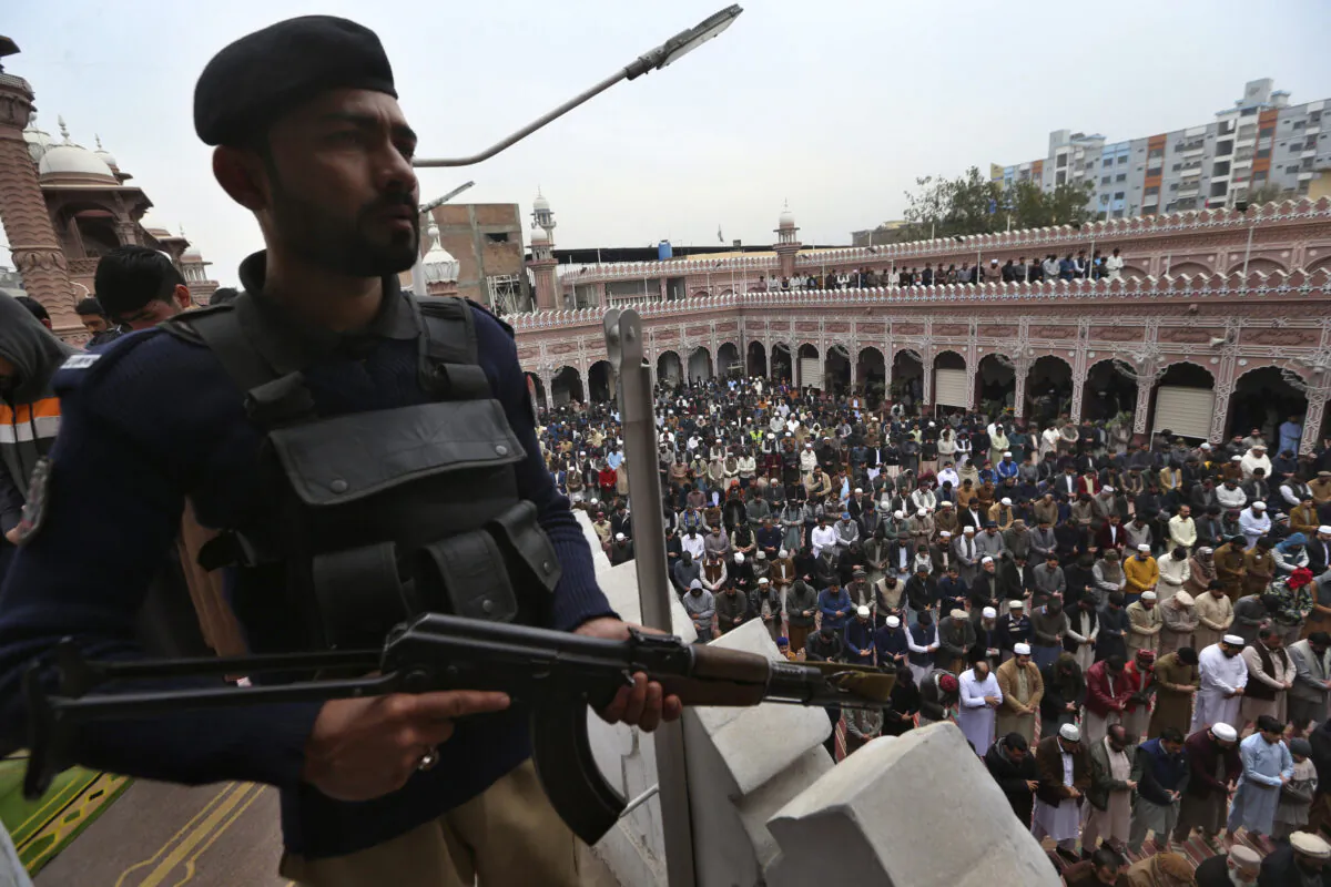 A police officer stands guard as people take part in Friday prayers at a mosque in Peshawar, Pakistan, on Feb. 3, 2023. (Muhammad Sajjad/AP Photo)