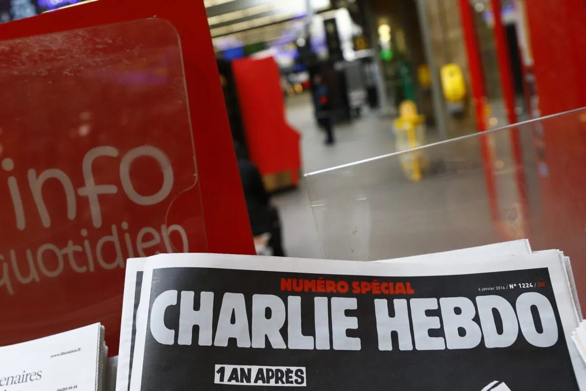 A special edition of the satirical newspaper Charlie Hebdo that marks one year after, "1 an apres" the attacks on it, on a newsstand at a train station in Paris on Jan. 6, 2016. (Francois Mori/AP Photo)