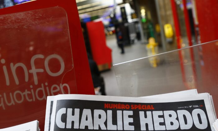 A special edition of the satirical newspaper Charlie Hebdo that marks one year after, "1 an apres" the attacks on it, on a newsstand at a train station in Paris on Jan. 6, 2016. (Francois Mori/AP Photo)