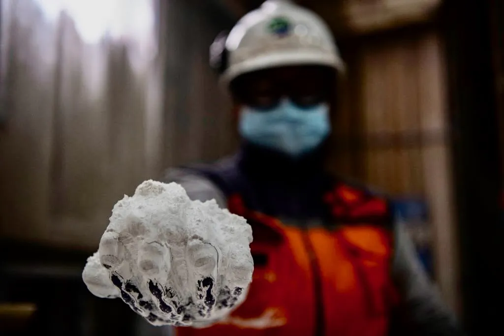 A worker displays 99.9 percent lithium inside the El Carmen Lithium processing plant of Chile's SQM (Sociedad Quimica Minera) in Antofagasta, Chile, on Sept. 13, 2022. (Martin Bernetti/ AFP via Getty Images)