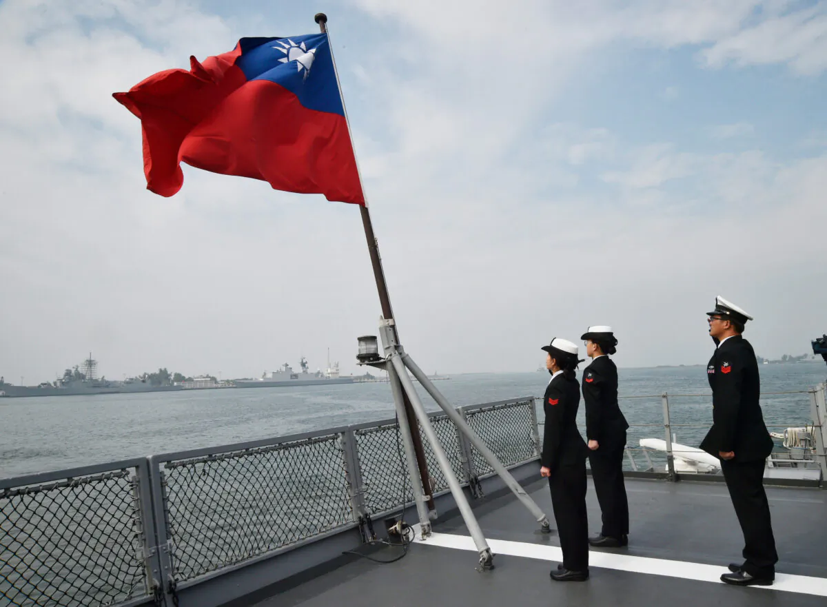 Taiwanese sailors salute the island's flag on the deck of the Panshih supply ship after taking part in annual drills, at the Tsoying naval base in Kaohsiung, Taiwan, on Jan. 31, 2018. (Mandy Cheng/AFP via Getty Images)
