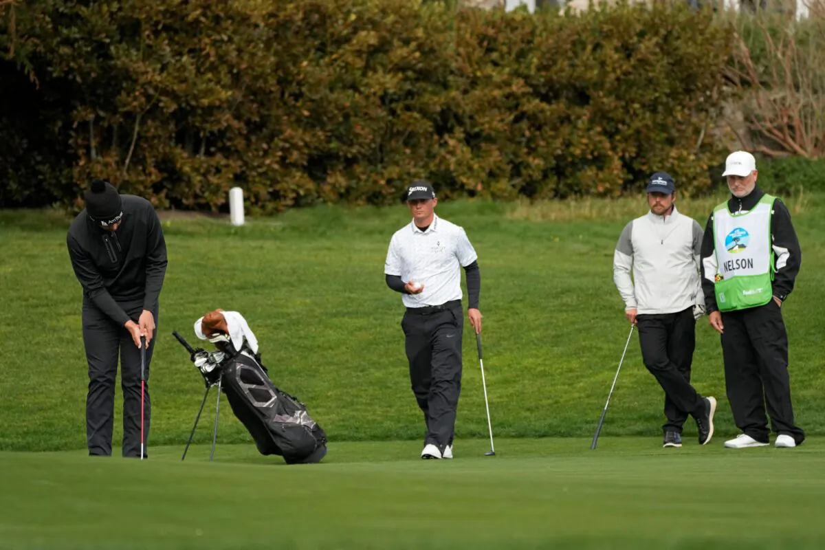 Beau Hossler (L), putts on the 13th green of the Pebble Beach Golf Links as Max McGreevy (C), and Lukas Nelson, second from right, look on during the second round of the AT&T Pebble Beach Pro-Am golf tournament in Pebble Beach, Calif., on Feb. 3, 2023. (Eric Risberg/AP Photo)