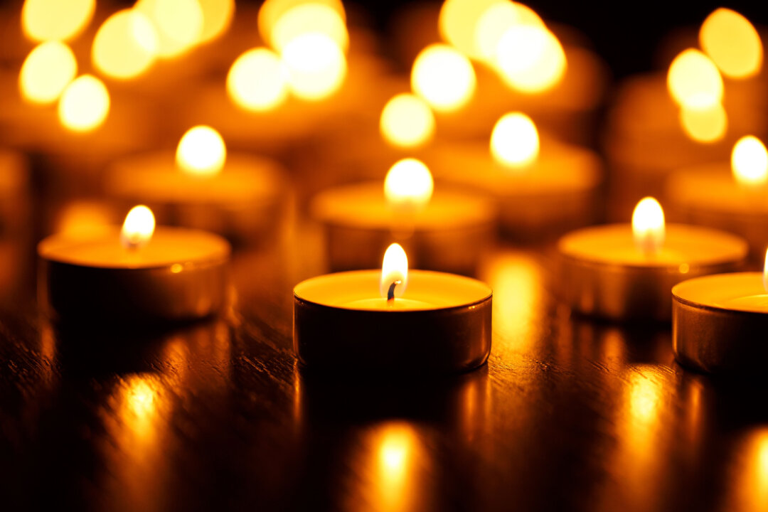 Many burning candles with concept of mourning the dead from the COVID-19 in China. (Vladyslav Starozhylov/Shutterstock).