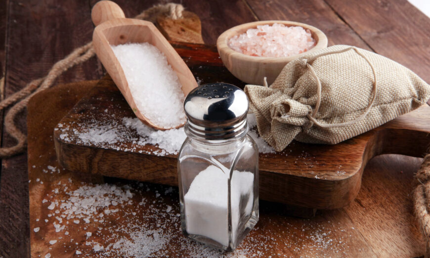 An assortment of different kinds of salt on a wooden table. (Shutterstock)