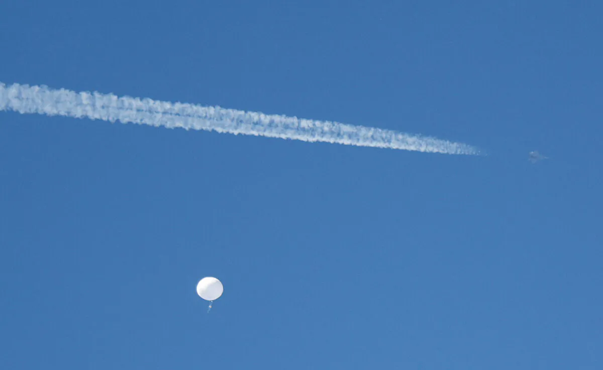A jet flies by a Chinese spy balloon as it floats off the coast in Surfside Beach, S.C., on Feb. 4, 2023. (Randall Hill/Reuters)