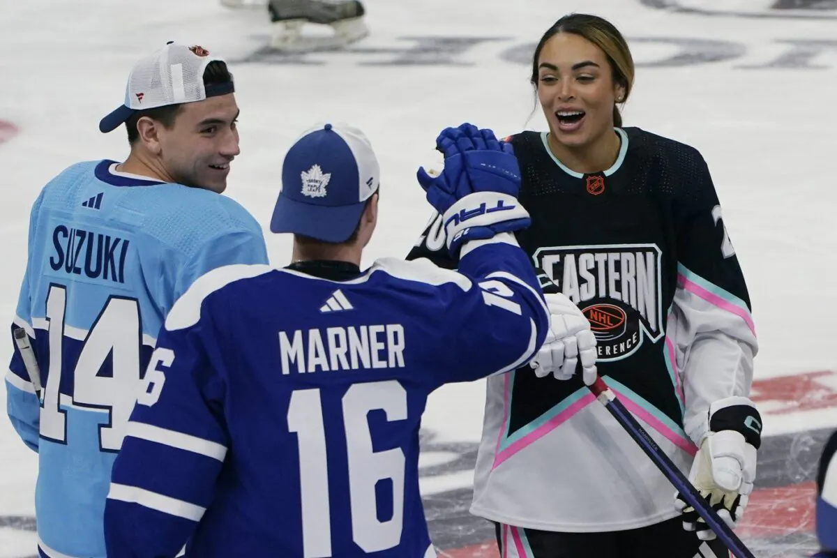Montreal Canadiens' Nick Suzuki (14) and Toronto Maple Leafs' Mitchell Marner (16) congratulate Canadian hockey player Sarah Nurse after she scored a goal during the NHL All Star Skills Showcase, Feb. 3, 2023, in Sunrise, Fla. (The Canadian Press/AP -Marta Lavandier)