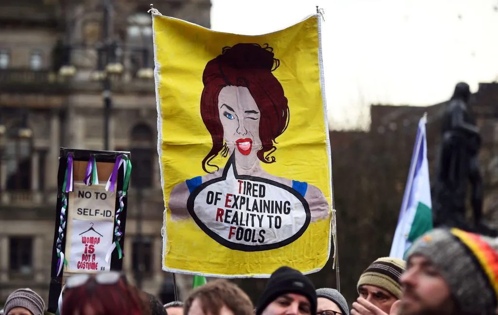 A demonstrator holds a placard while attending the "Let Women Speak" rally in George, Square, in Glasgow, on February 5, 2023. (Photo by Andy Buchanan / AFP) 