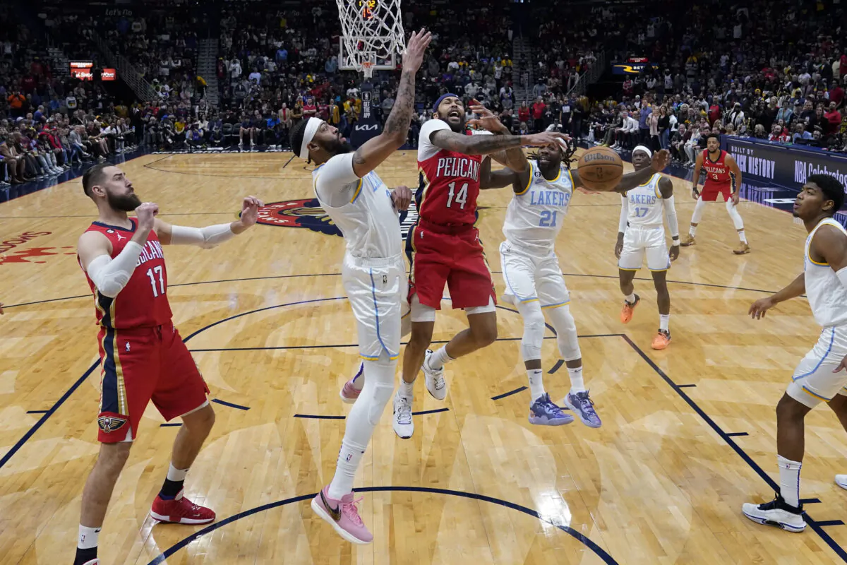 New Orleans Pelicans forward Brandon Ingram (14) goes to the basket between Los Angeles Lakers forward Anthony Davis and guard Patrick Beverley (21) in the first half of an NBA basketball game 