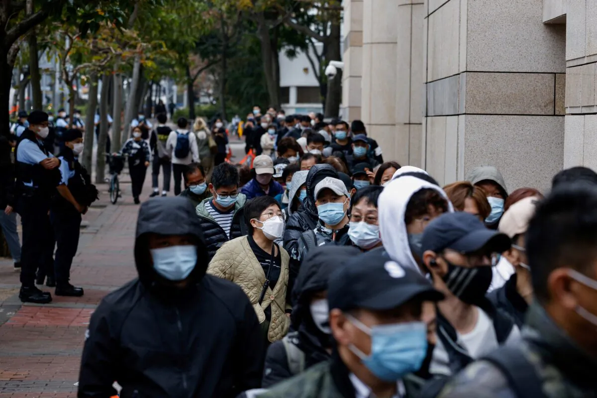 People queue outside the West Kowloon Magistrates' Courts building during the hearing of the 47 pro-democracy activists charged with conspiracy to commit subversion under the national security law, in Hong Kong, on Feb. 6, 2023. (Tyrone Siu/Reuters)