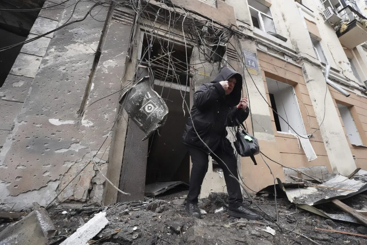 A woman walks out from a residential building which was hit by a Russian rocket in the city center of Kharkiv, Ukraine, on Feb. 5, 2023. (Andrii Marienko/AP Photo)