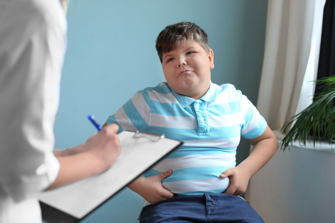 Overweight boy consulting with doctor in office. (Shutterstock)