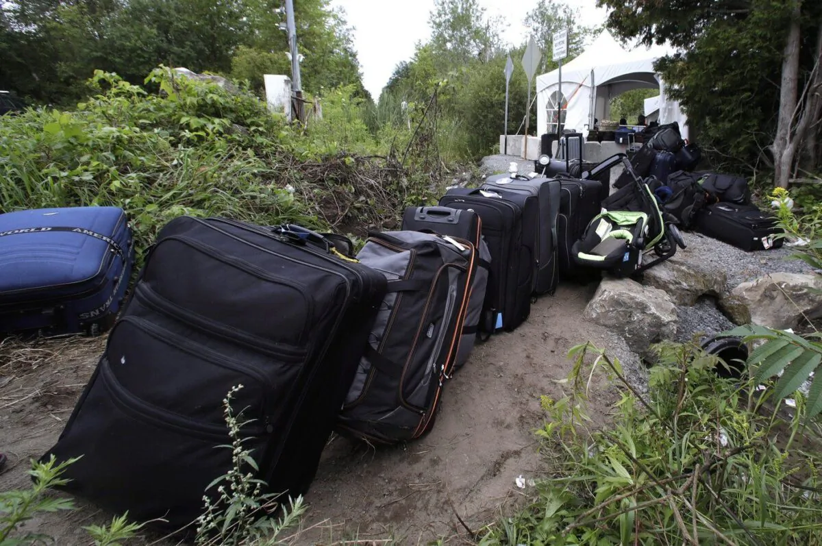 Luggage from migrants fills a pathway at an illegal crossing point from Champlain, N.Y., to Saint-Bernard-de-Lacolle, Que., Aug. 7, 2017. (The Canadian Press/Charles Krupa)