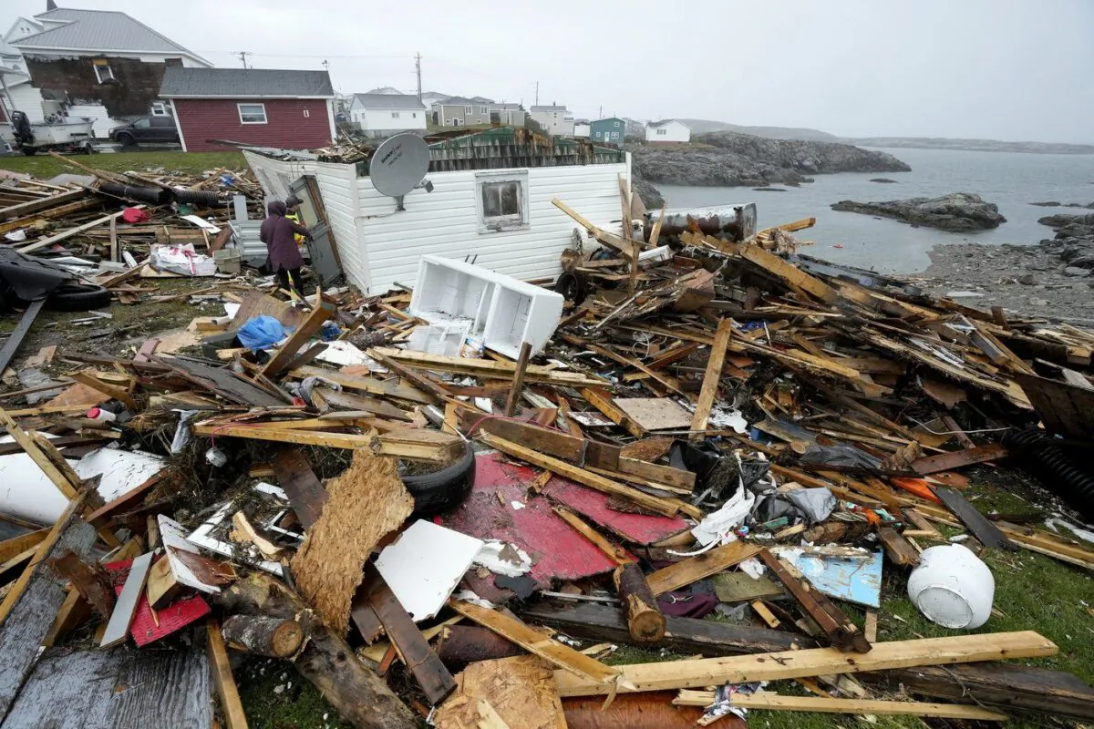 A resident and search and rescue worker examine the destroyed remains of a home in Port aux Basques, N.L., Sept.26, 2022. (The Canadian Press/Frank Gunn)