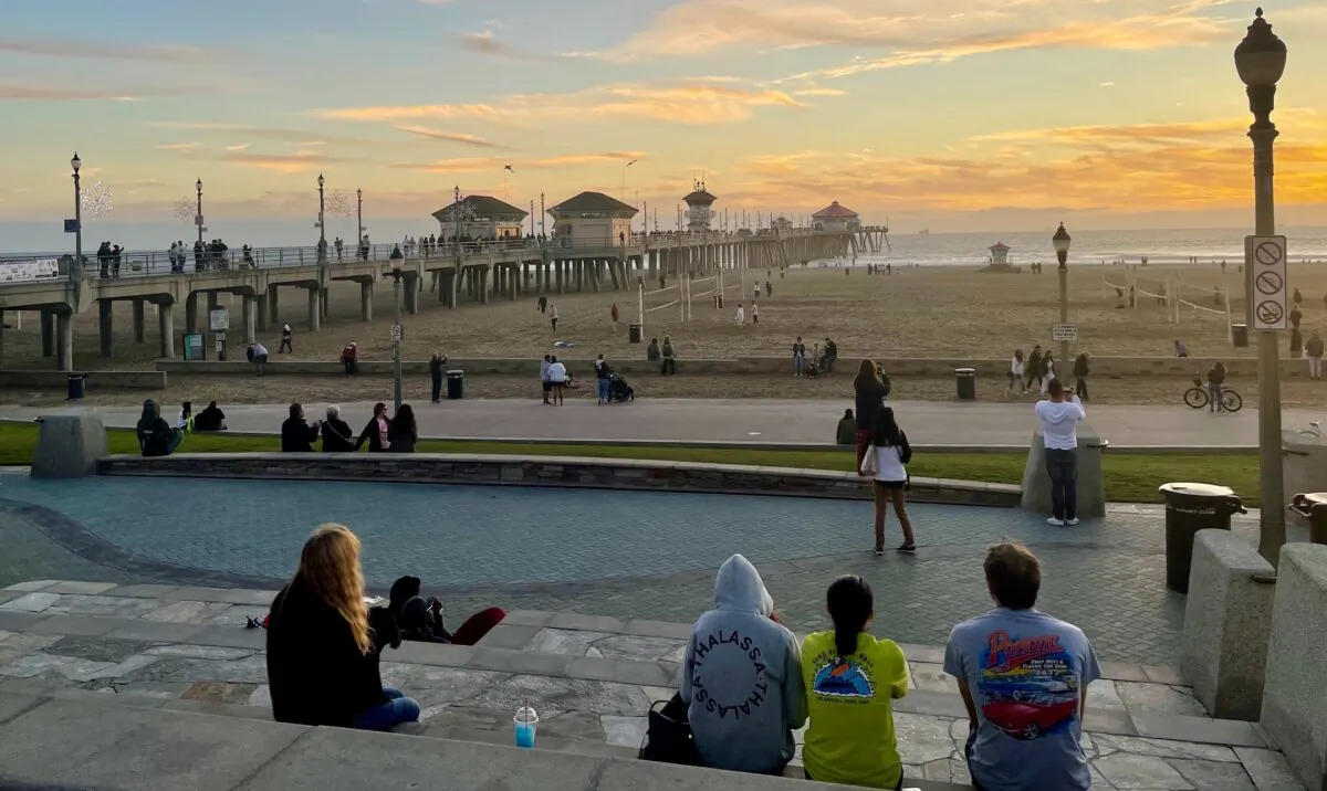 People enjoy the sunset in Huntington Beach, Calif., on Dec. 28, 2022. (Carol Cassis/The Epoch Times)