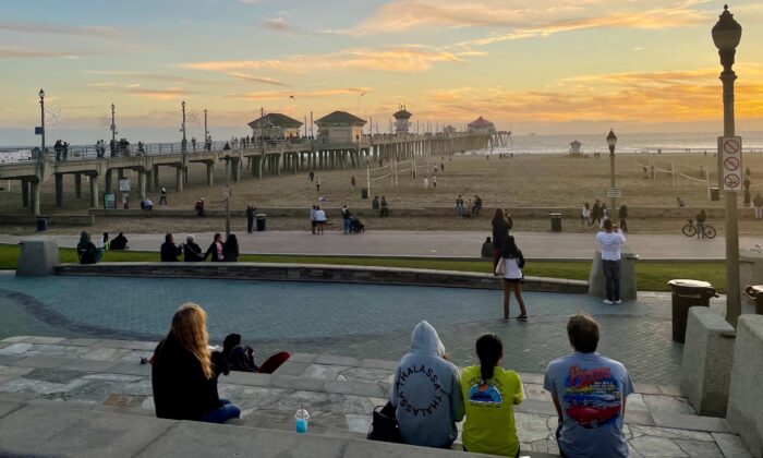 People enjoy the sunset in Huntington Beach, Calif., on Dec. 28, 2022. (Carol Cassis/The Epoch Times)