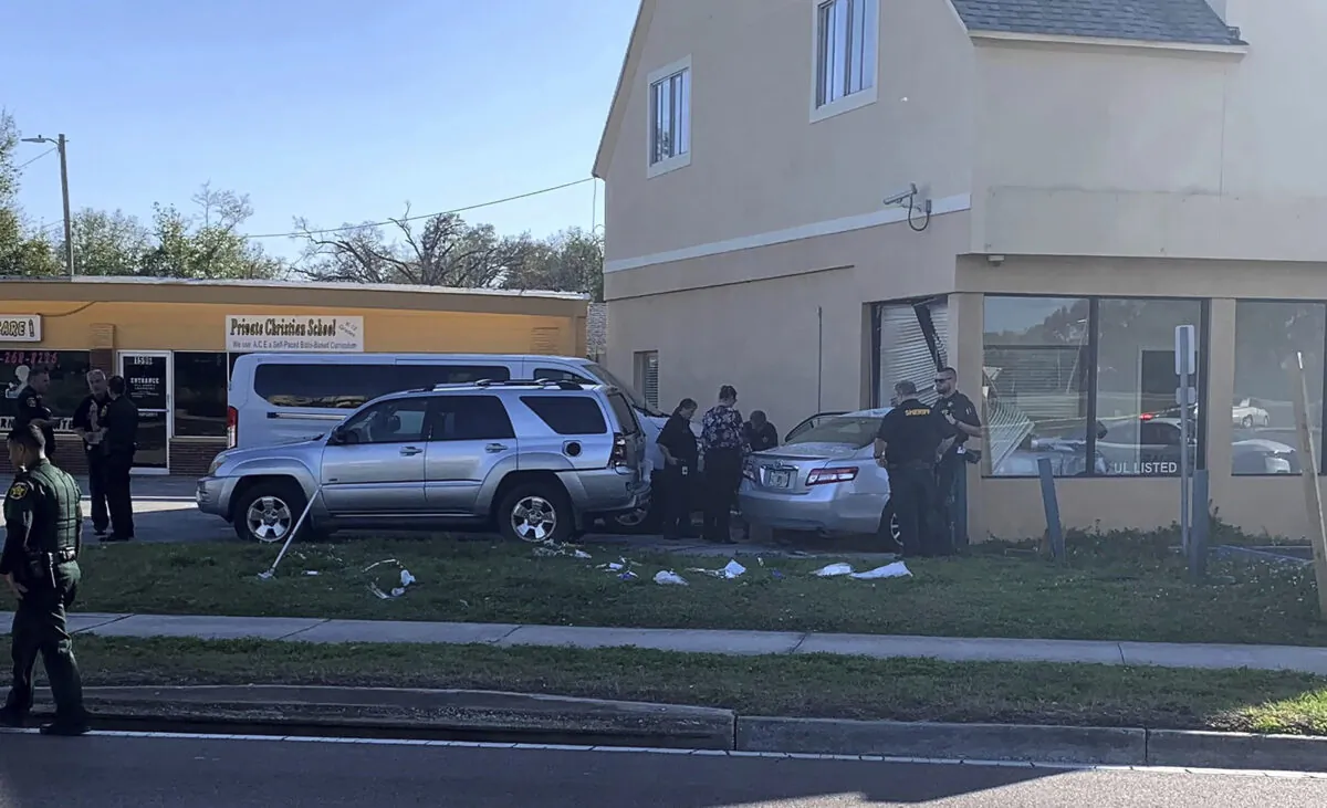 Law enforcement investigators examine a vehicle after it crashed into the side of a building in Winter Haven, Fla., on Feb. 6, 2023. (Sara Megan Walsh/The Ledger via AP)