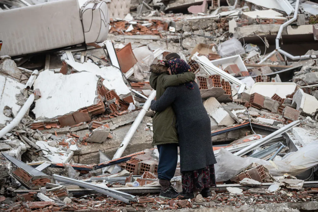 Women hug each other near the collapsed building  in Hatay, Turkey., on Feb. 7, 2023. (Burak Kara/Getty Images)