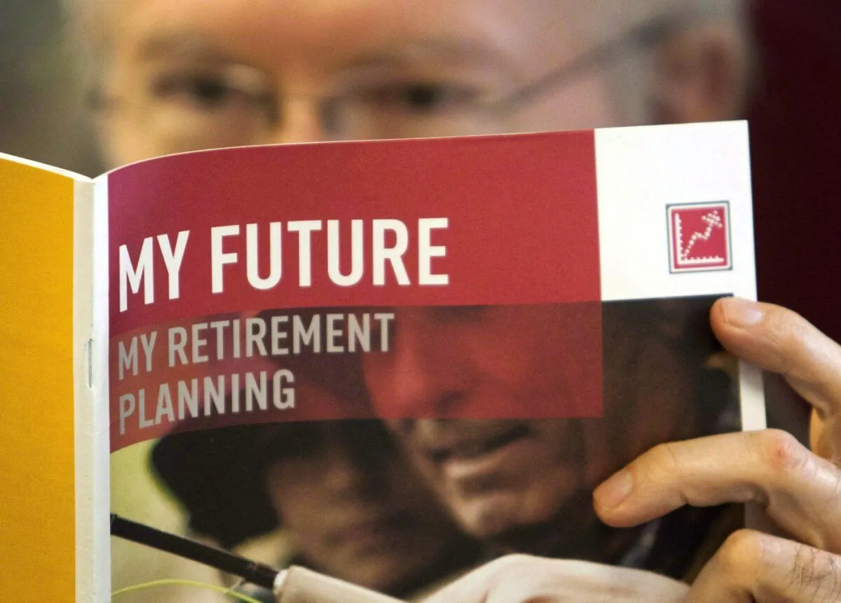 Canadians now believe they need $1.7 million in savings in order to retire, a 20 per cent increase from 2020, according to a new BMO survey. A man looks over a brochures offering various retirement savings options Feb. 3, 2012 in Montreal. (The Canadian Press/Ryan Remiorz)