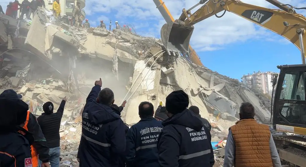 A rescue team searches for a mother and daughter trapped under the rubble of a 14-floor building that collapsed following the first of two earthquakes in Adana province, Turkey, on Feb. 7, 2023. (Ercan Koc for The Epoch Times)