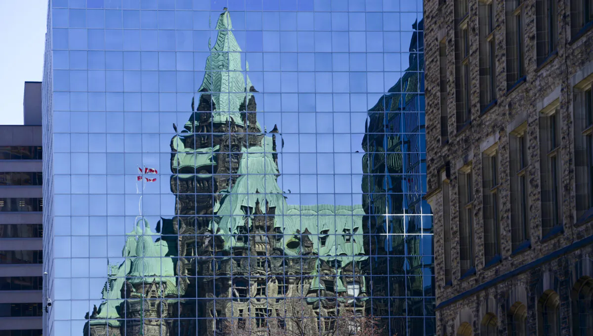 The Confederation Building reflects off the windows of a building in downtown Ottawa on April 7, 2020. (The Canadian Press/Sean Kilpatrick)