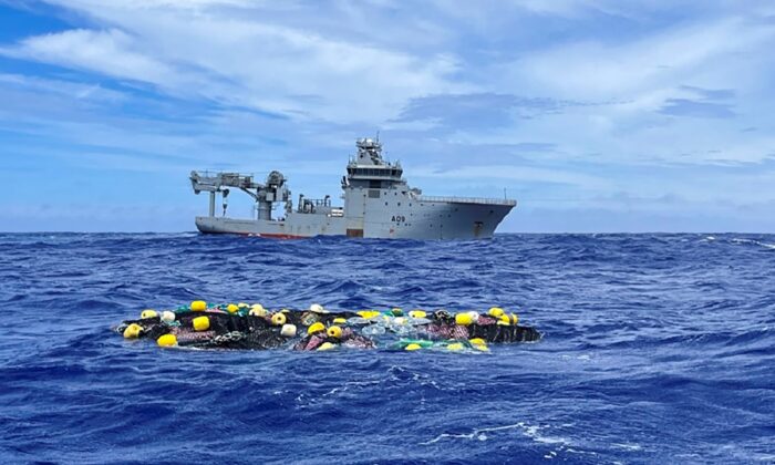 A shipment of cocaine floats on the surface of the Pacific Ocean with Royal New Zealand Navy vessel HMNZS Manawanui behind in an undated photo. (NZ Police via AP)