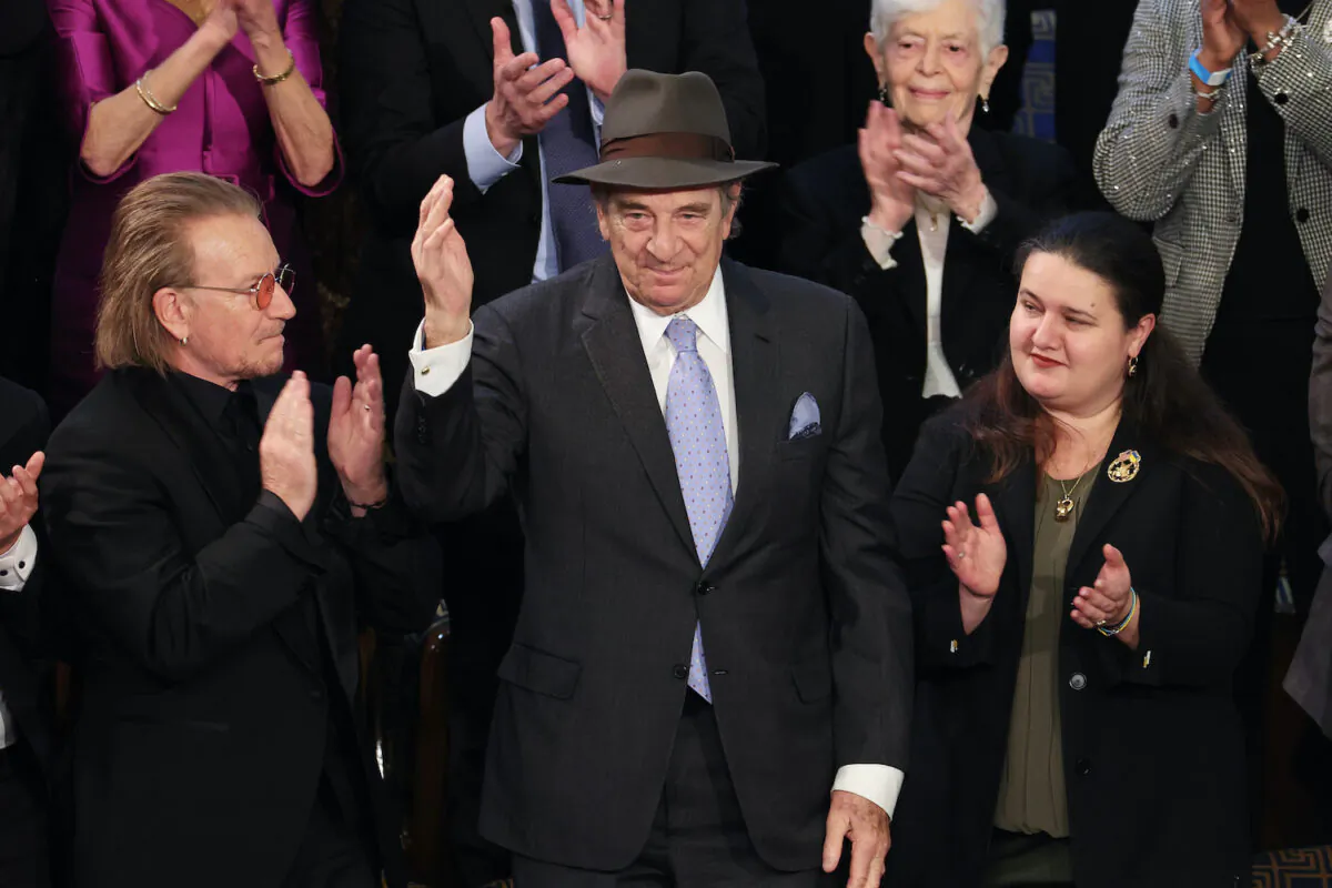 Paul Pelosi, husband of Rep. Nancy Pelosi (D-Calif) (center) acknowledges the audience as Irish singer-songwriter Bono (left) and Ukrainian Ambassador to the U.S. Oksana Markarova applaud during U.S. President Joe Biden's State of the Union address in the House Chambers of the U.S. Capitol in Washington on Feb. 7, 2023. (Win McNamee/Getty Images)