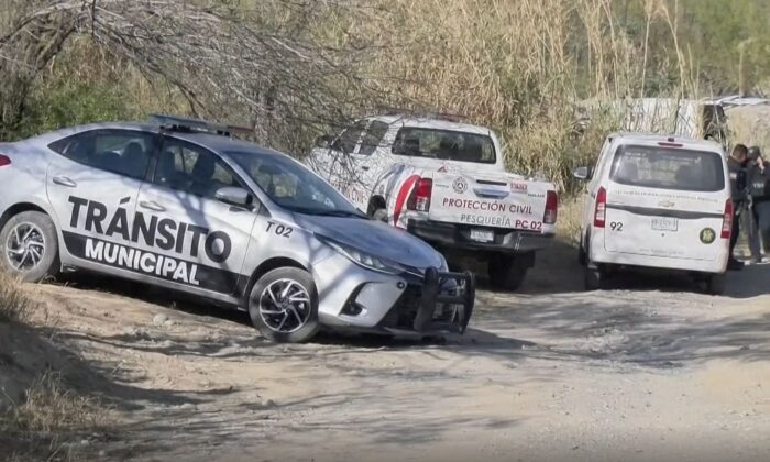 Police and Civil Protection vehicles at a cordoned-off area where authorities found bodies of 14 people in an overturned pickup truck in Pesquería, Mexico, on Feb. 7, 2023, in a still from video. (Televisa via AP/Screenshot via The Epoch Times)