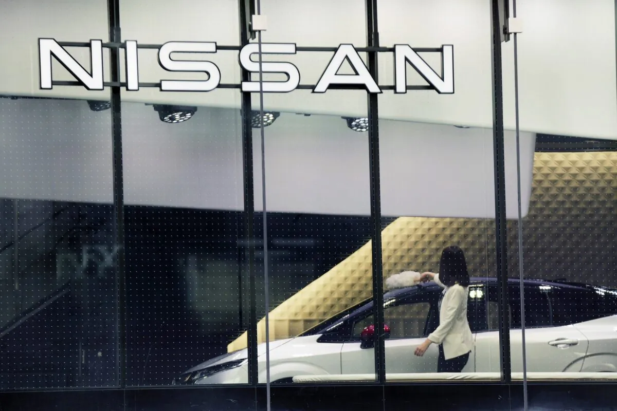 A staff of Nissan car showroom wipes a car in Tokyo on Jan. 31, 2022. (Eugene Hoshiko/AP Photo)