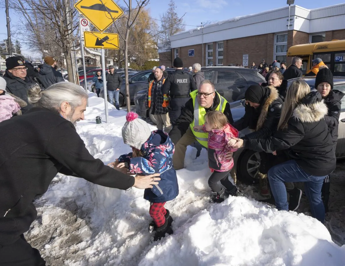 Parents and their children are loaded onto a warming bus as they wait for news after a bus crashed into a daycare centre in Laval, Que., on Feb. 8, 2023. (The Canadian Press/Ryan Remiorz
Ryan Remiorz)