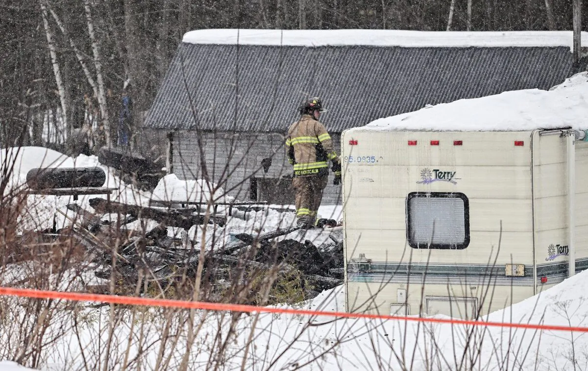 An emergency worker is shown at the scene of a fatal fire at a home in Ste-Julienne, Que., Feb. 9, 2023. (The Canadian Press/Graham Hughes)