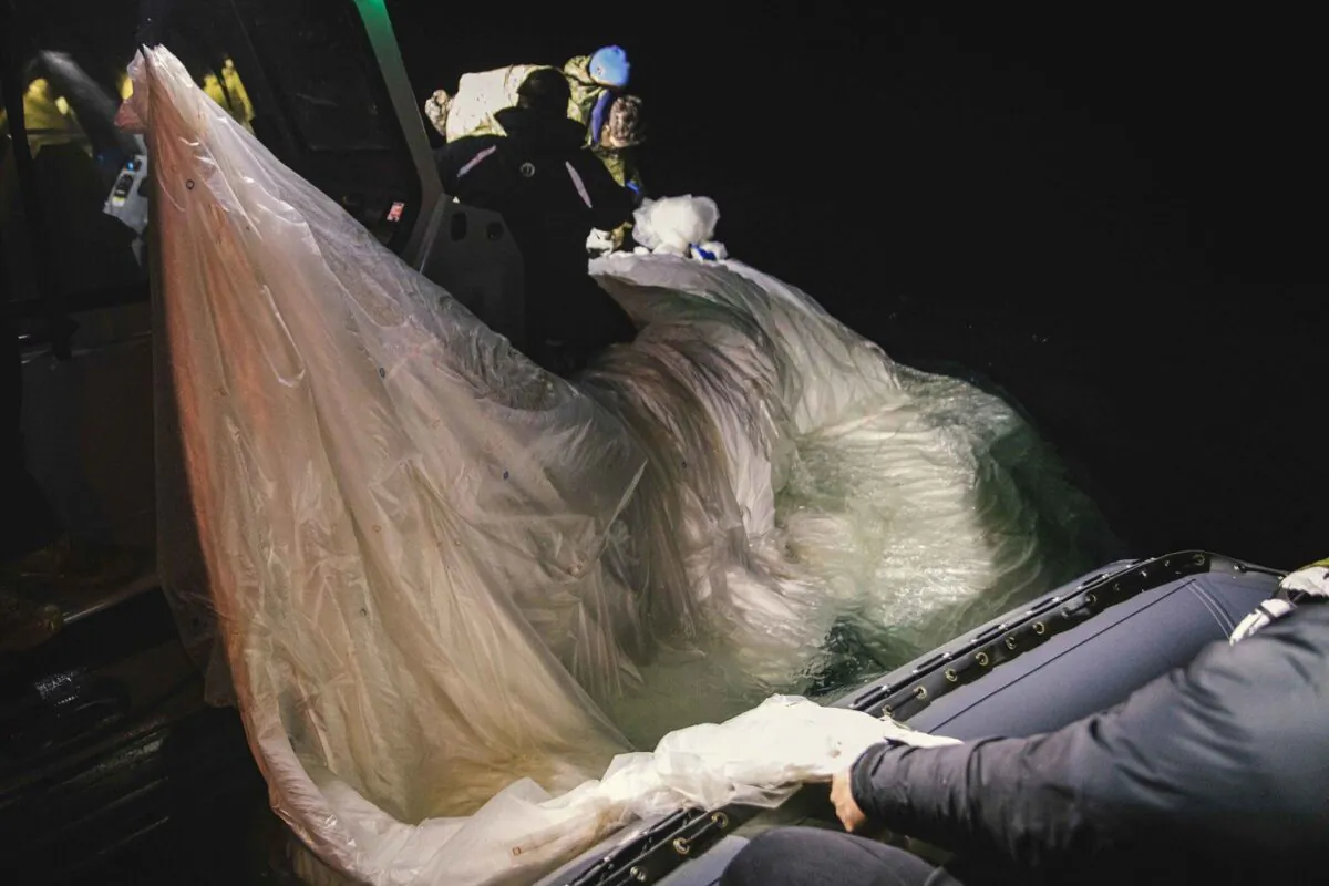 This image provided by the U.S. Navy shows sailors assigned to Explosive Ordnance Disposal Group 2 recovering a high-altitude surveillance balloon off the coast of Myrtle Beach, S.C., Feb. 5, 2023. (The Canadian Press/U.S. Navy via AP)
