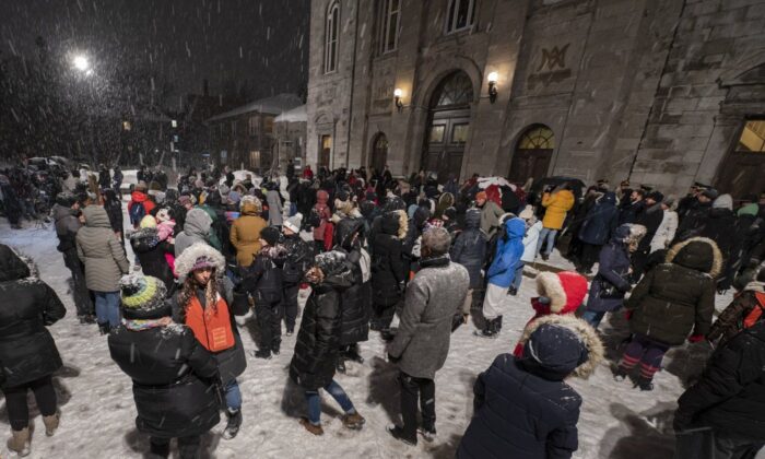 People gather for an all-night vigil at a church near the daycare center where two children died after a municipal bus crashed into the building on February 9, 2023 in Laval, Coué.  (The Canadian Press/Peter McCabe)