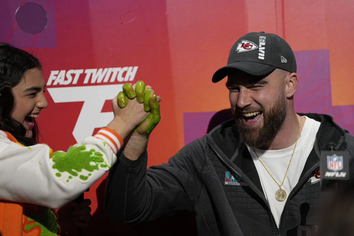 Kansas City Chiefs tight end Travis Kelce speaks with a youngster during the NFL football Super Bowl 57 opening night in Phoenix on Feb. 6, 2023. (David J. Philip/AP Photo)